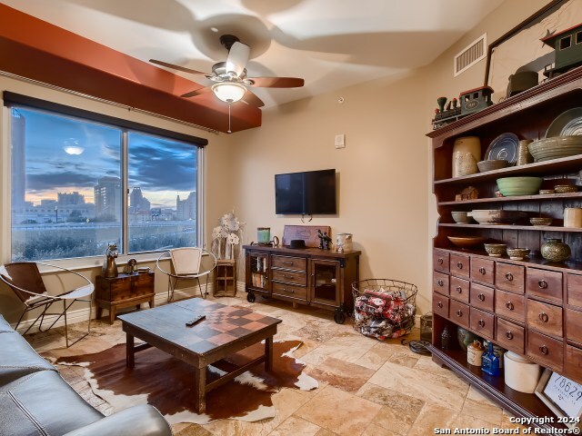 215 Center St Unit 307, San Antonio, TX 78202 - living area with a ceiling fan and light stone finish floors