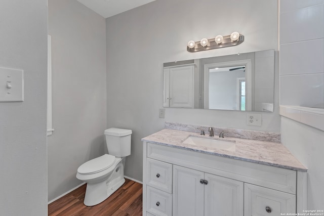 bathroom with hardwood / wood-style floors, vanity, and toilet