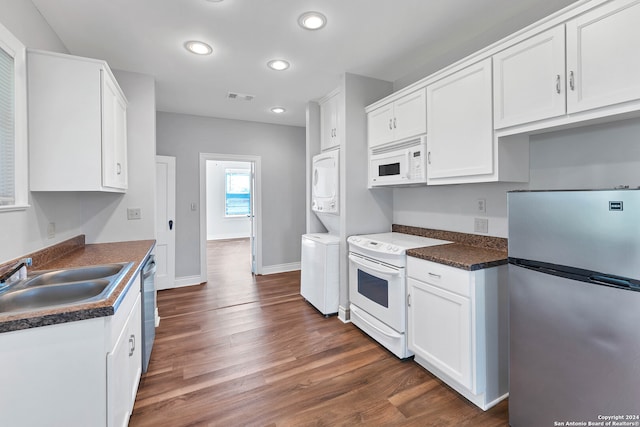 kitchen featuring stacked washer and dryer, dark hardwood / wood-style flooring, sink, white cabinetry, and appliances with stainless steel finishes