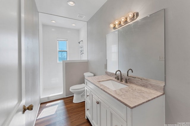 bathroom featuring walk in shower, large vanity, wood-type flooring, and toilet