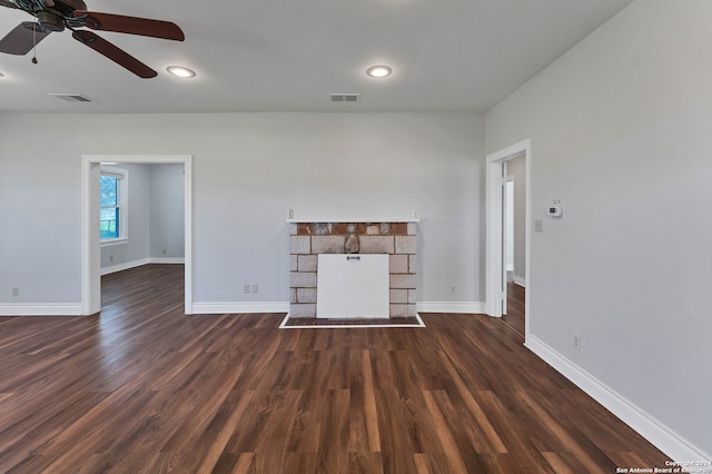 unfurnished living room with ceiling fan, a fireplace, and dark wood-type flooring