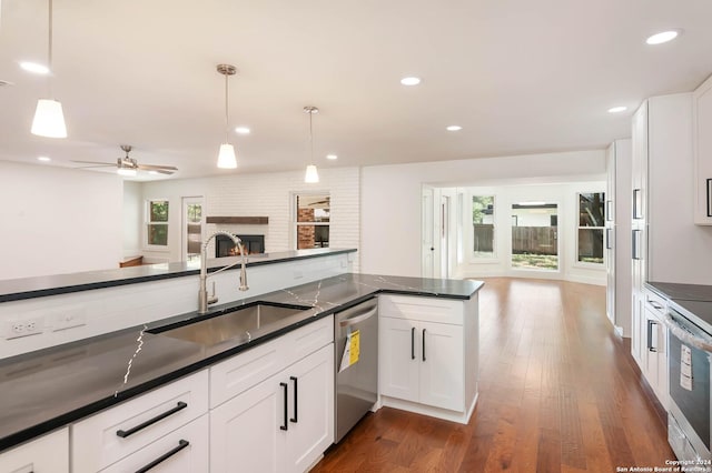 kitchen featuring pendant lighting, white cabinetry, sink, and stainless steel dishwasher