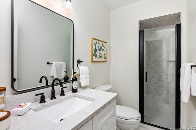 bathroom featuring vanity, toilet, and walk in shower