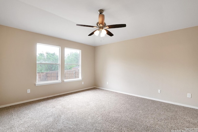 carpeted spare room featuring ceiling fan