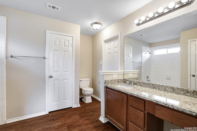 bathroom featuring a shower, vanity, wood-type flooring, and toilet