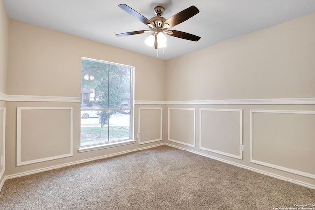 carpeted spare room with ceiling fan