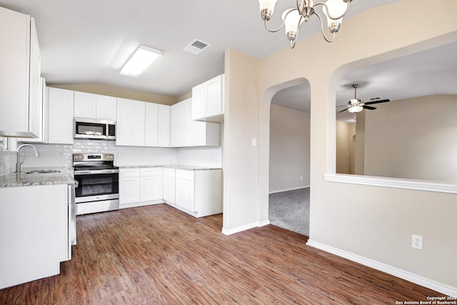 kitchen featuring white cabinetry, sink, vaulted ceiling, decorative backsplash, and appliances with stainless steel finishes