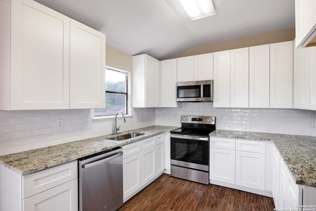 kitchen with sink, white cabinets, stainless steel appliances, and lofted ceiling