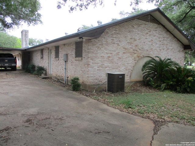 view of side of home with a carport and central air condition unit