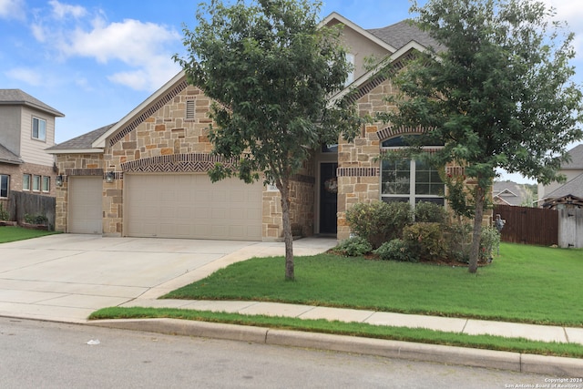 view of property hidden behind natural elements with a garage and a front lawn