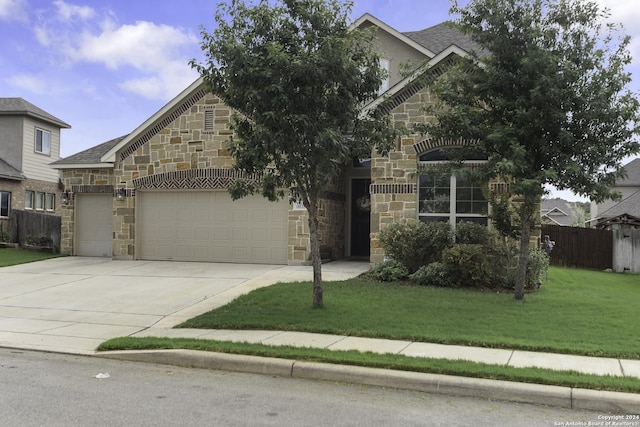 view of property hidden behind natural elements featuring a garage and a front yard