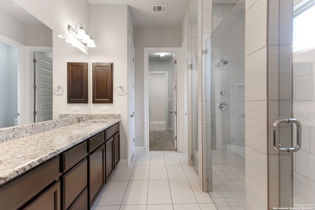 bathroom featuring a shower with door, tile patterned flooring, and vanity