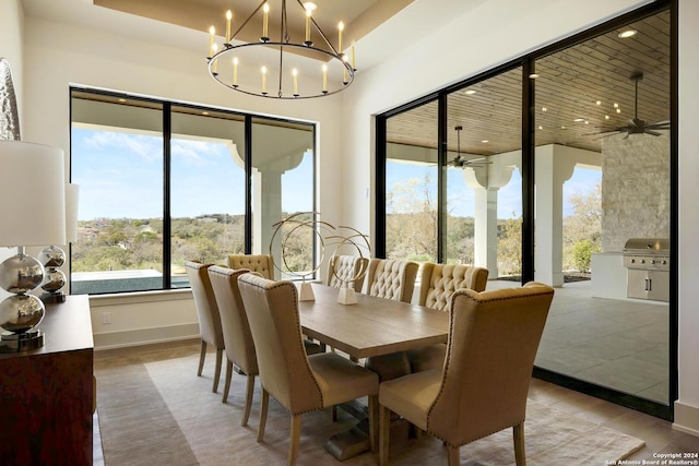 dining area with ceiling fan with notable chandelier and wood-type flooring