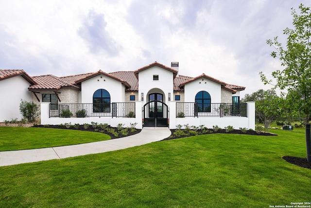 mediterranean / spanish-style home with french doors and a front yard