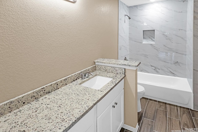 full bathroom featuring toilet, tiled shower / bath, and vanity