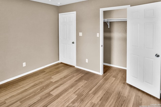 unfurnished bedroom with light hardwood / wood-style floors and a closet