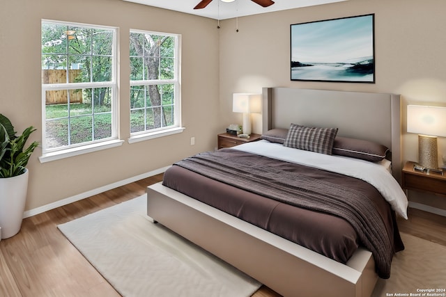 bedroom featuring wood-type flooring, multiple windows, and ceiling fan