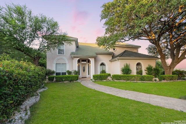 mediterranean / spanish-style home with a lawn