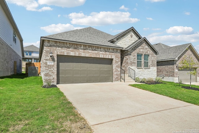 view of front facade with central AC unit, a front lawn, and a garage