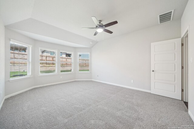 empty room featuring ceiling fan, carpet, and lofted ceiling