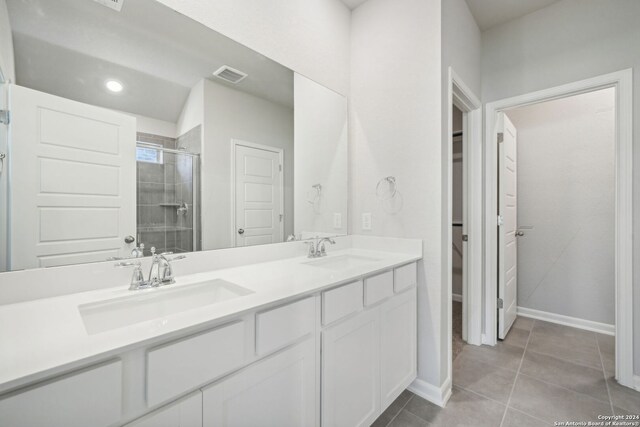 bathroom featuring tile patterned floors, a shower with door, and vanity