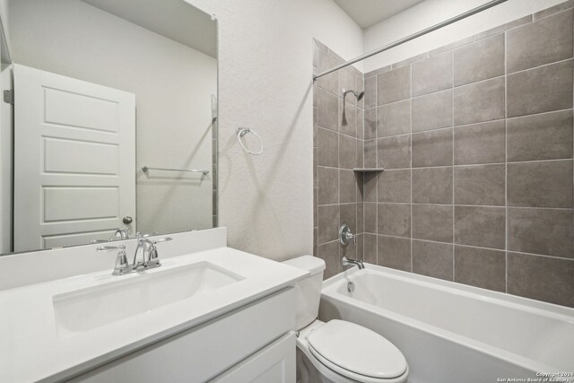 full bathroom with tiled shower / bath combo, vanity, and toilet