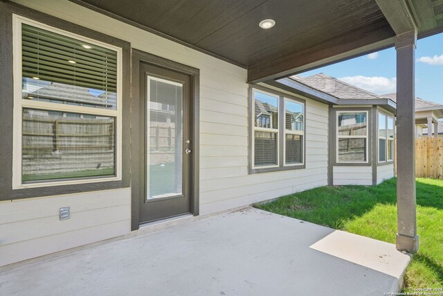 doorway to property featuring a patio area and a yard