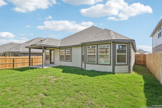 rear view of property featuring a lawn and a patio