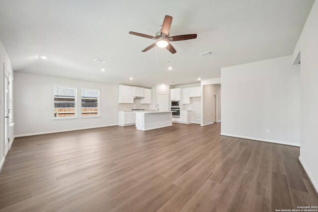 unfurnished living room with ceiling fan, dark hardwood / wood-style floors, and sink