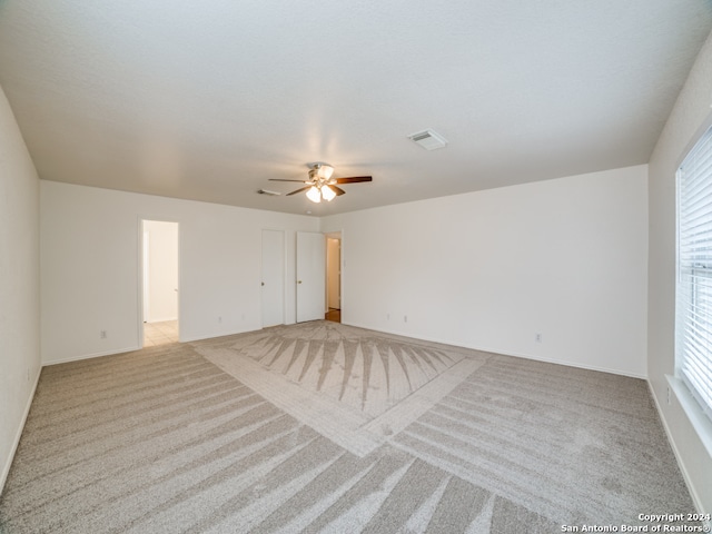 carpeted spare room featuring ceiling fan