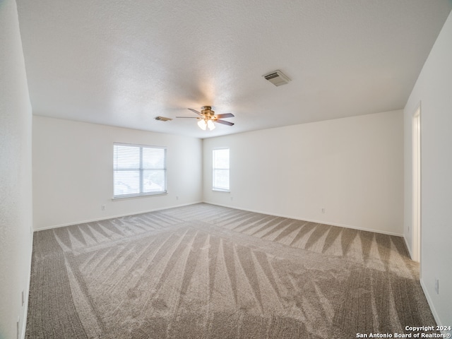 carpeted empty room featuring a textured ceiling