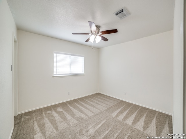 spare room with ceiling fan and light carpet