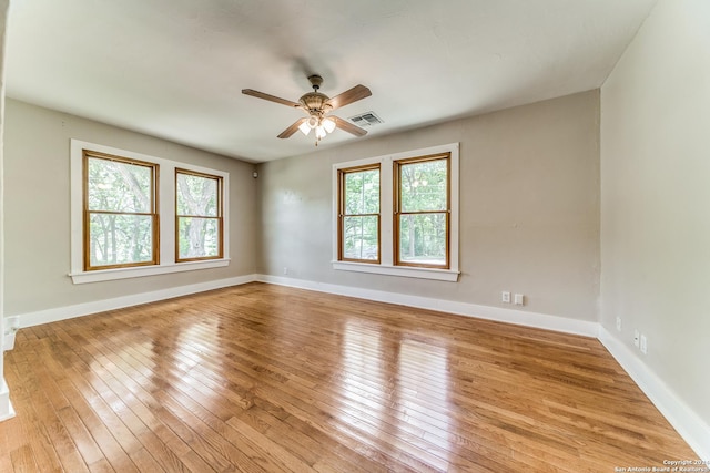 spare room featuring ceiling fan, light hardwood / wood-style floors, and a wealth of natural light