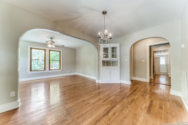 unfurnished dining area featuring light hardwood / wood-style floors and ceiling fan with notable chandelier