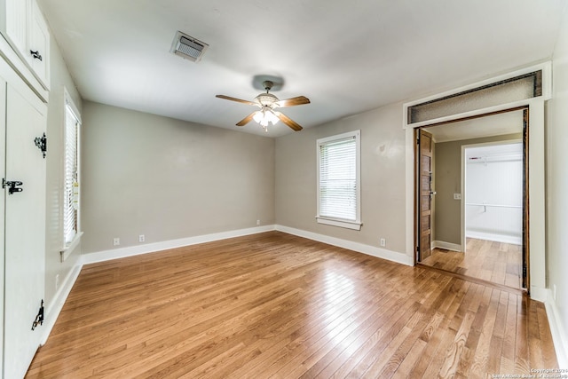 unfurnished bedroom featuring ceiling fan, light hardwood / wood-style floors, and a closet