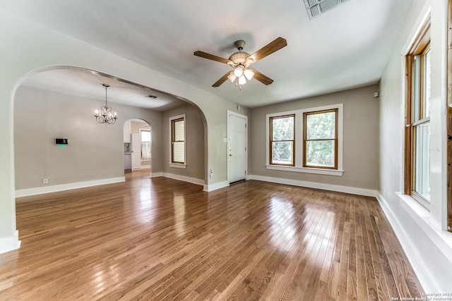 interior space featuring ceiling fan with notable chandelier and hardwood / wood-style flooring