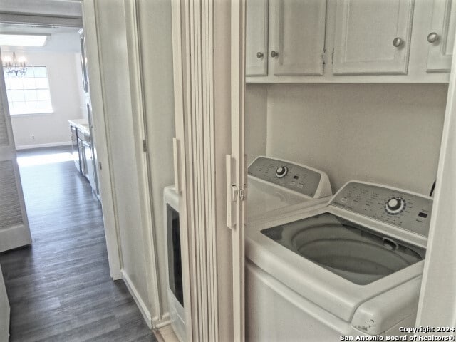 laundry area with washer and dryer, dark hardwood / wood-style flooring, and cabinets