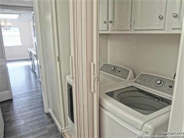 clothes washing area featuring baseboards, cabinet space, dark wood-type flooring, and washer and clothes dryer