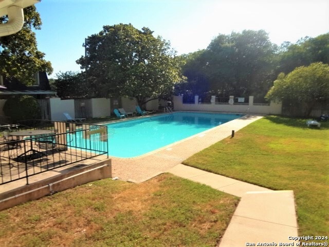 view of pool featuring a patio area and a yard