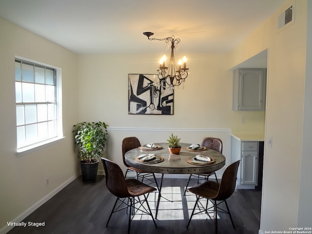 dining area with dark hardwood / wood-style flooring and a notable chandelier