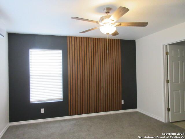 carpeted spare room with a wealth of natural light and ceiling fan