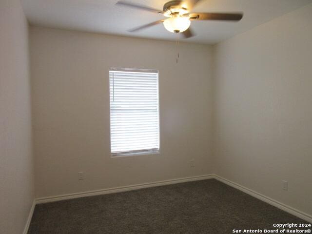 carpeted spare room featuring ceiling fan