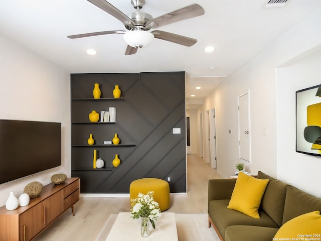 living room with ceiling fan, built in features, and light wood-type flooring