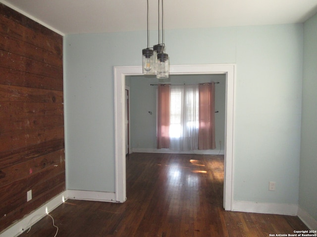 unfurnished dining area with dark wood-type flooring