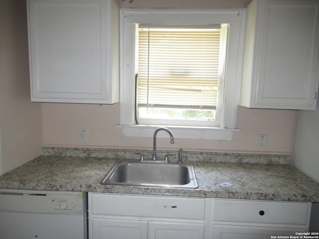 kitchen featuring dishwasher, sink, and white cabinetry