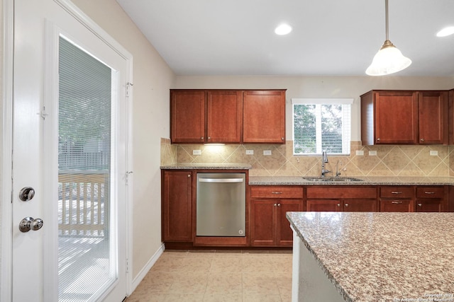 kitchen with light stone countertops, sink, hanging light fixtures, and tasteful backsplash