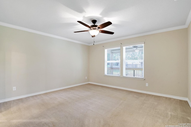 carpeted spare room with crown molding and ceiling fan