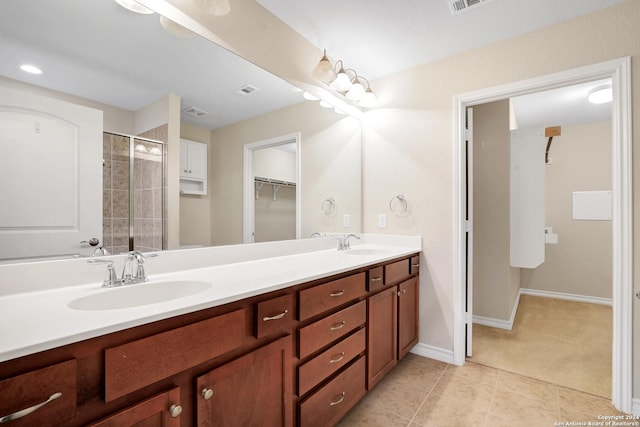 bathroom featuring tile patterned flooring, vanity, and a shower with shower door