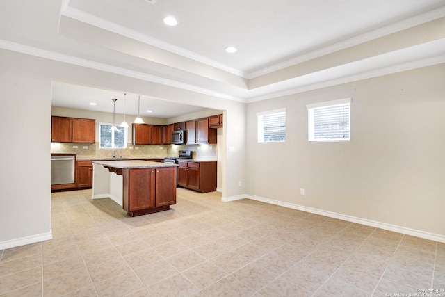 kitchen featuring a kitchen bar, stainless steel appliances, a tray ceiling, a kitchen island, and hanging light fixtures