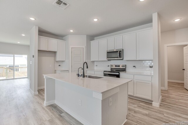 kitchen with white cabinetry, sink, an island with sink, and appliances with stainless steel finishes